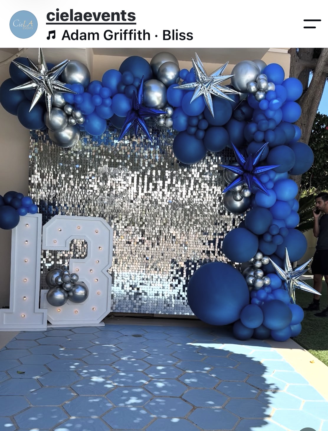 Blue and silver balloon garland framing a sequin shimmer wall and illuminated 13 marquee numbers