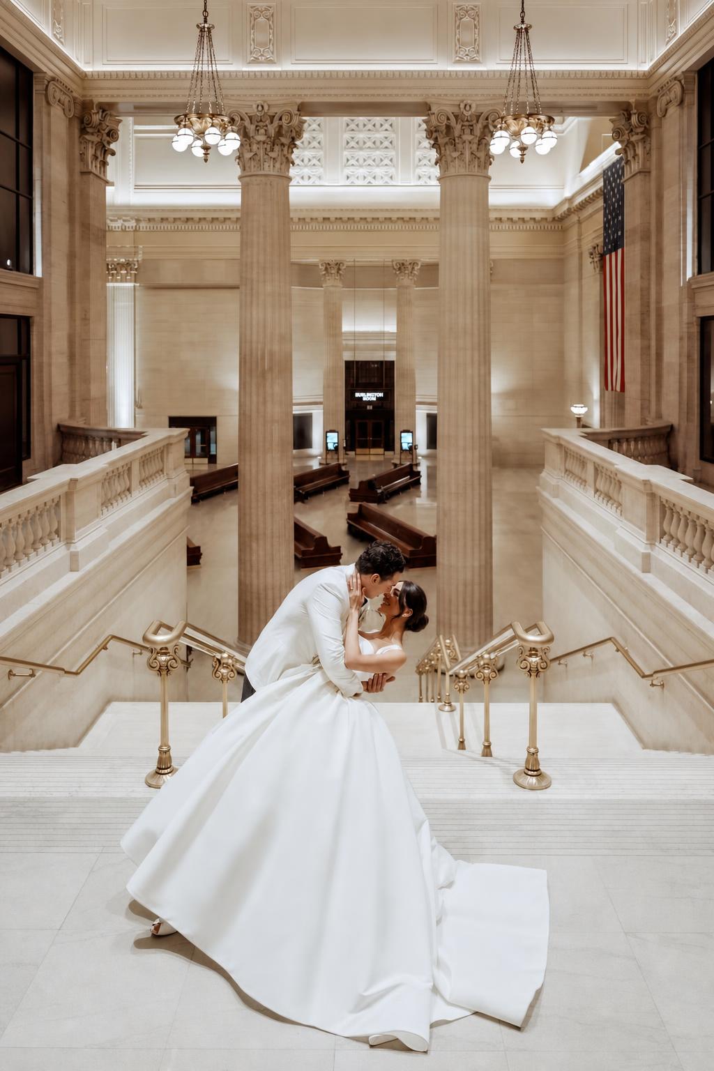 Bride and groom on a grand staircase at a celebration planned by Michigan Avenue Events