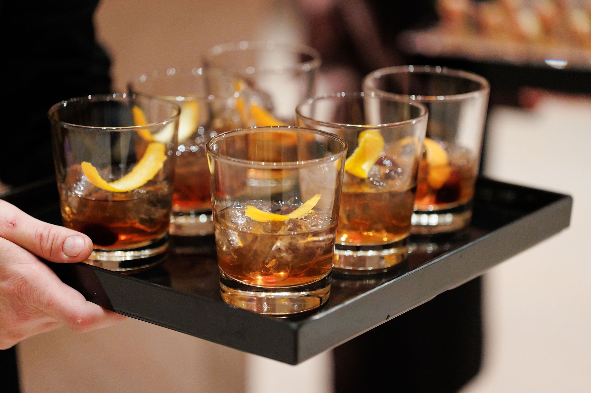 Tray of old fashioned cocktails with orange twists passed during cocktail hour at Lavi and Sid's reception