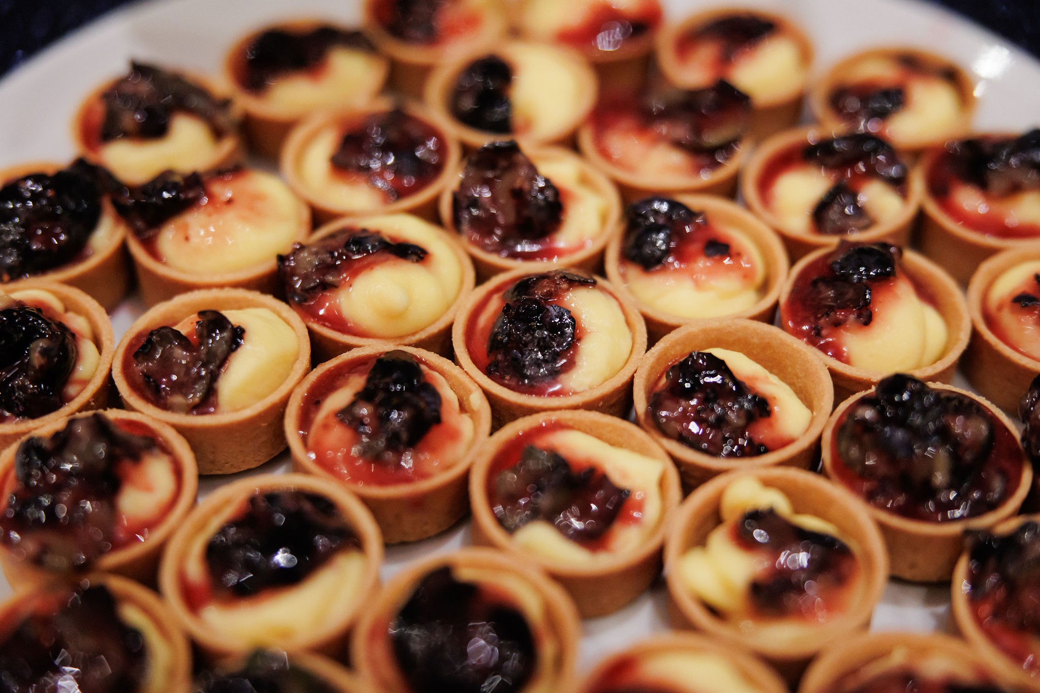 Platter of bite-size custard tartlets topped with berry compote at Lavi and Sid's reception
