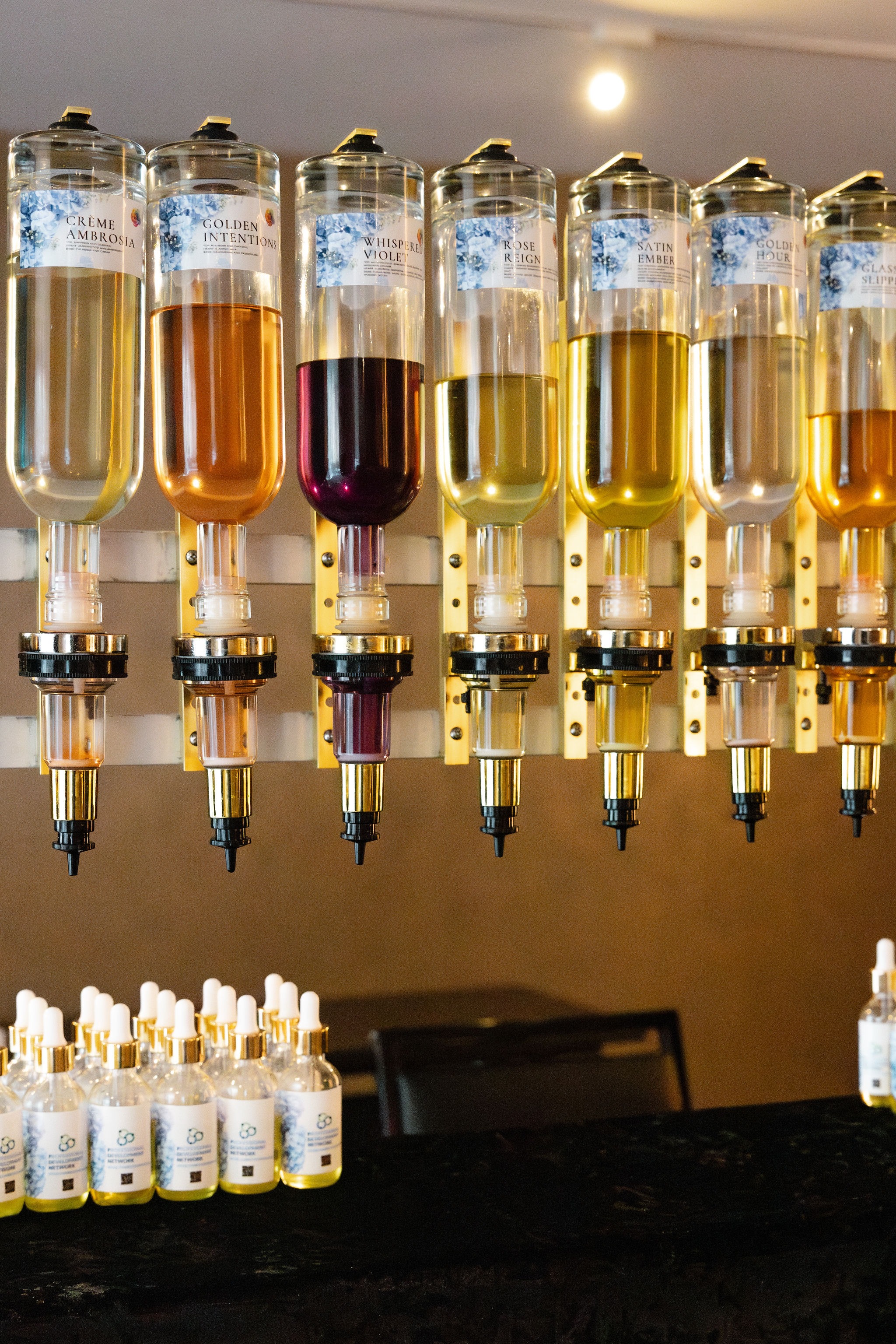 Custom fragrance bar with labeled scent dispensers and branded dropper bottles