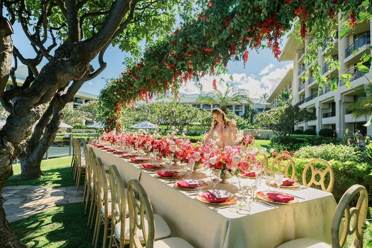 Brianne Garritano reviewing a floral canopy table on a resort lawn