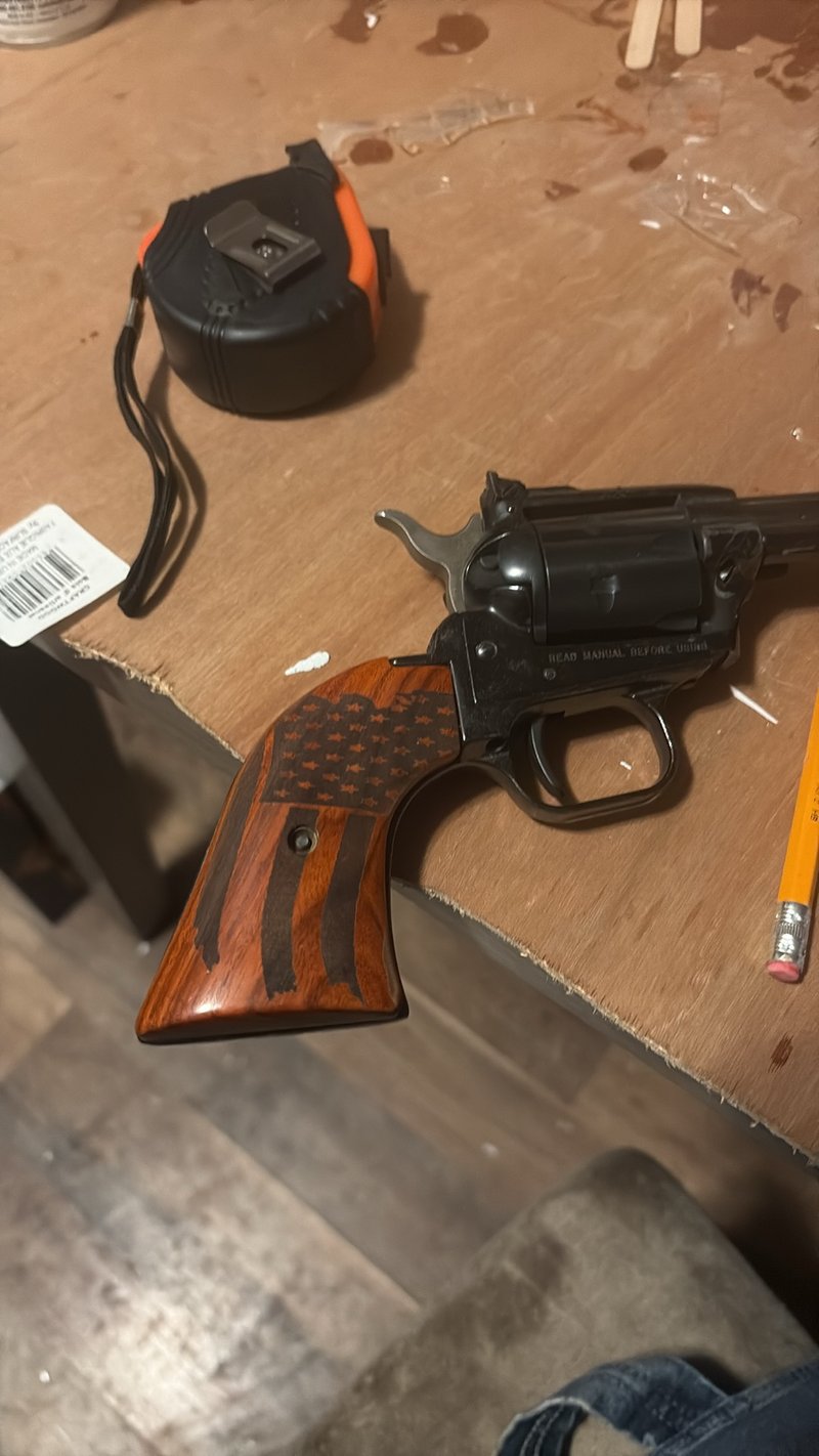 A wooden revolver grip engraved with a stars and stripes flag