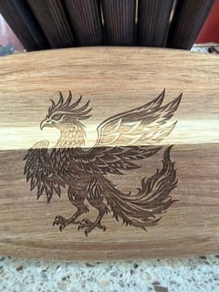 A two-tone wooden board engraved with a phoenix